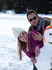 Image showing portrait of happy young couple with snowman