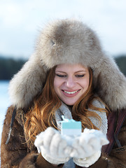 Image showing portrait of  girl with gift at winter scene and snow in backgron