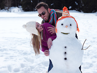 Image showing portrait of happy young couple with snowman