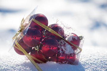 Image showing christmas balls in box on fresh  snow