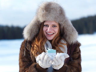 Image showing portrait of  girl with gift at winter scene and snow in backgron