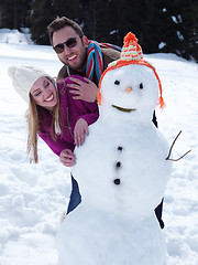 Image showing portrait of happy young couple with snowman