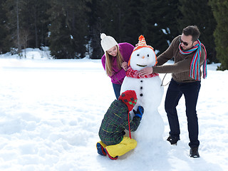 Image showing happy family making snowman