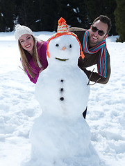 Image showing portrait of happy young couple with snowman