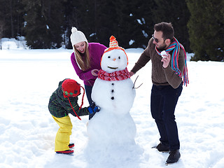 Image showing happy family making snowman