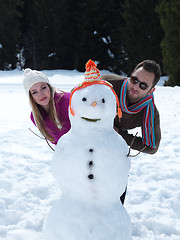 Image showing portrait of happy young couple with snowman