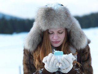 Image showing portrait of  girl with gift at winter scene and snow in backgron