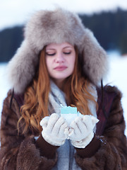 Image showing portrait of  girl with gift at winter scene and snow in backgron