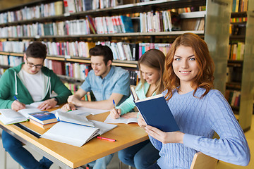 Image showing happy students reading books in library
