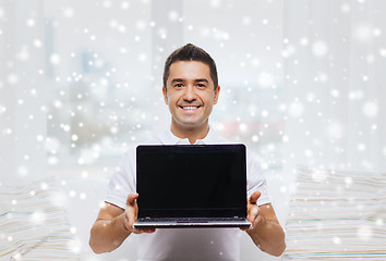 Image showing happy man showing laptop blank screen at home