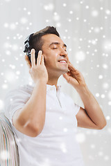 Image showing happy man in headphones listening to music at home