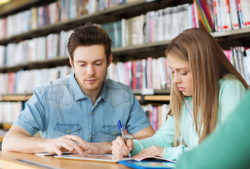 Image showing students writing to notebooks in library