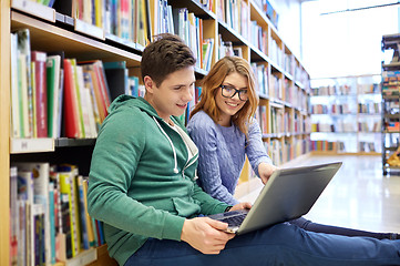 Image showing happy students with laptop in library