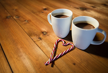 Image showing christmas candy canes and cups on wooden table