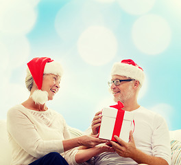 Image showing happy senior couple with gift box at home