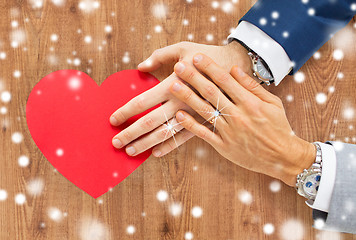 Image showing close up of male gay couple hands with red heart