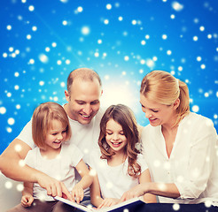 Image showing happy family with book at home