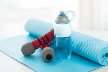 Image showing close up of bottle, dumbbells and sports mat