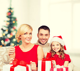 Image showing smiling family holding many gift boxes