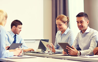 Image showing smiling business people with tablet pc in office