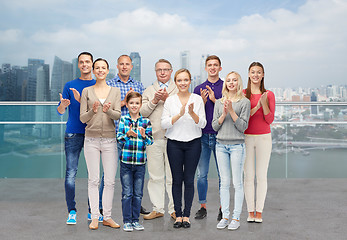 Image showing group of people applauding over city waterside