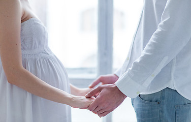 Image showing The young couple  dressed in white standing at home