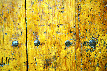 Image showing metal nail dirty  yellow  stripped paint in the brown    