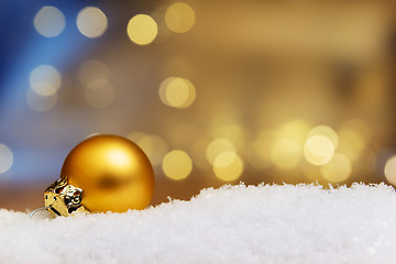 Image showing Golden bauble on snow