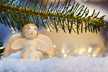 Image showing branch, felt angel on snow and bokeh lights