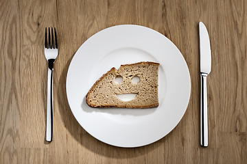 Image showing bread with smiling face on a white plate