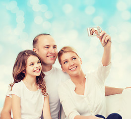 Image showing happy family with camera at home