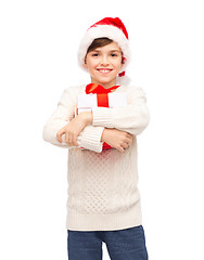 Image showing smiling happy boy in santa hat with gift box