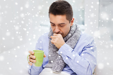 Image showing ill man with flu drinking tea and coughing at home
