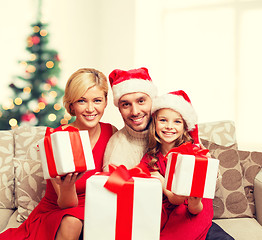 Image showing smiling family giving many gift boxes