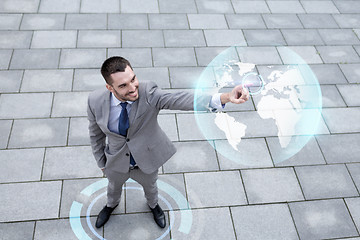 Image showing smiling businessman with globe projection outdoors