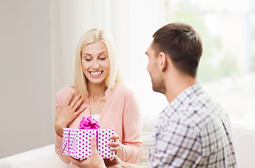 Image showing happy man giving woman gift box at home