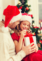 Image showing smiling father and daughter opening gift box