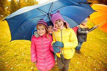 Image showing happy children with umbrella in autumn park