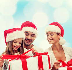 Image showing happy family in santa helper hats with gift boxes