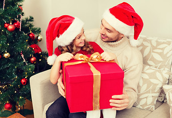 Image showing smiling father and daughter opening gift box