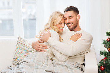 Image showing happy couple hugging on sofa at home