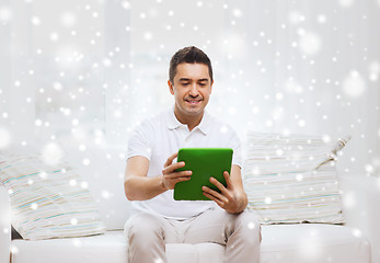 Image showing smiling man working with tablet pc at home