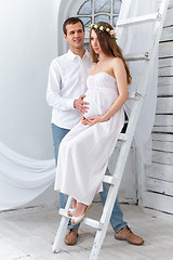 Image showing Cheerful young couple  dressed in white standing at home