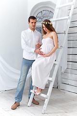 Image showing Cheerful young couple  dressed in white standing at home