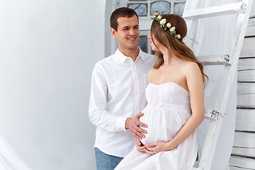 Image showing Cheerful young couple  dressed in white standing at home