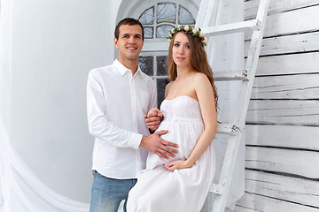 Image showing Cheerful young couple  dressed in white standing at home