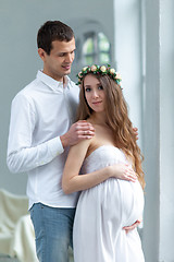 Image showing Cheerful young couple  dressed in white standing at home