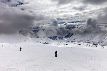 Image showing Skiers on ski slope before rain