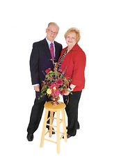 Image showing Dressed up senior couple with flowers.