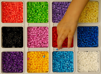 Image showing Child playing with toy pearls